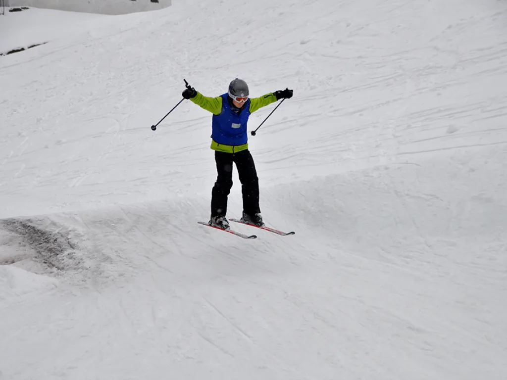 Skifahrer breitet auf der Piste die Arme aus.